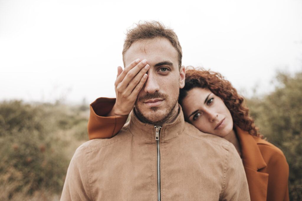 couple women covering man eyes trying to overcome Relationship Anxiety